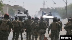 Members of the Iraqi security forces clash with protesters during a demonstration in Nasiriyah city, 375 km (233 miles) south of Baghdad, Aug. 31, 2013.
