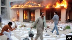 Angry Pakistani protesters seen after setting electrical company office on fire in Gujranwala, near Lahore, Oct 3, 2011.