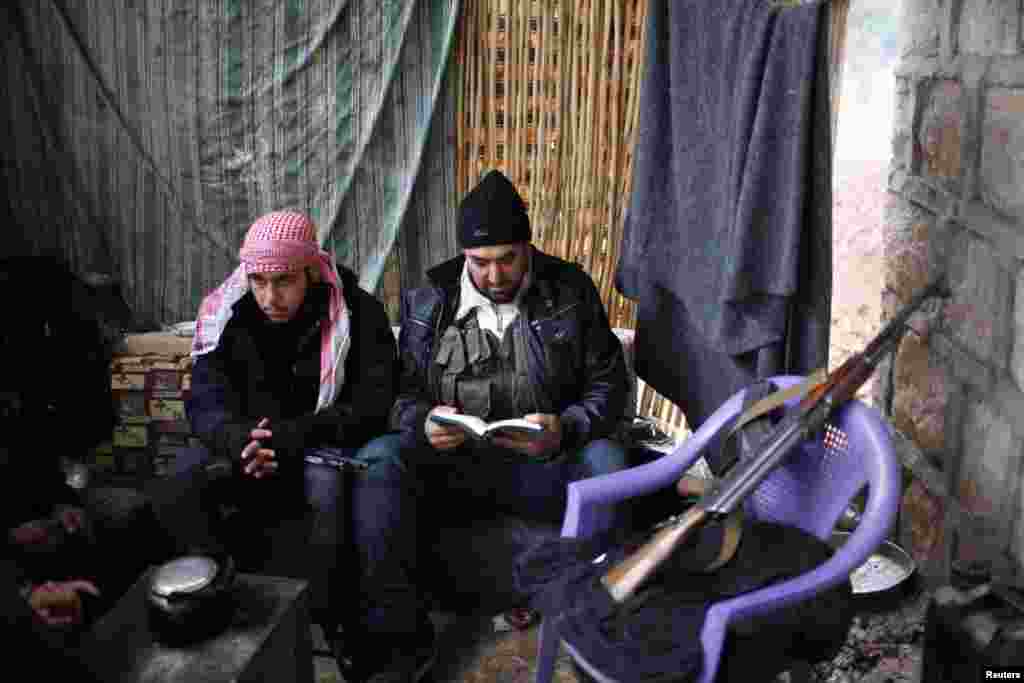 A Free Syrian Army fighter, whose comrades are surrounding a military airport, reads the Quran, Aleppo, Syria, December 20, 2012.