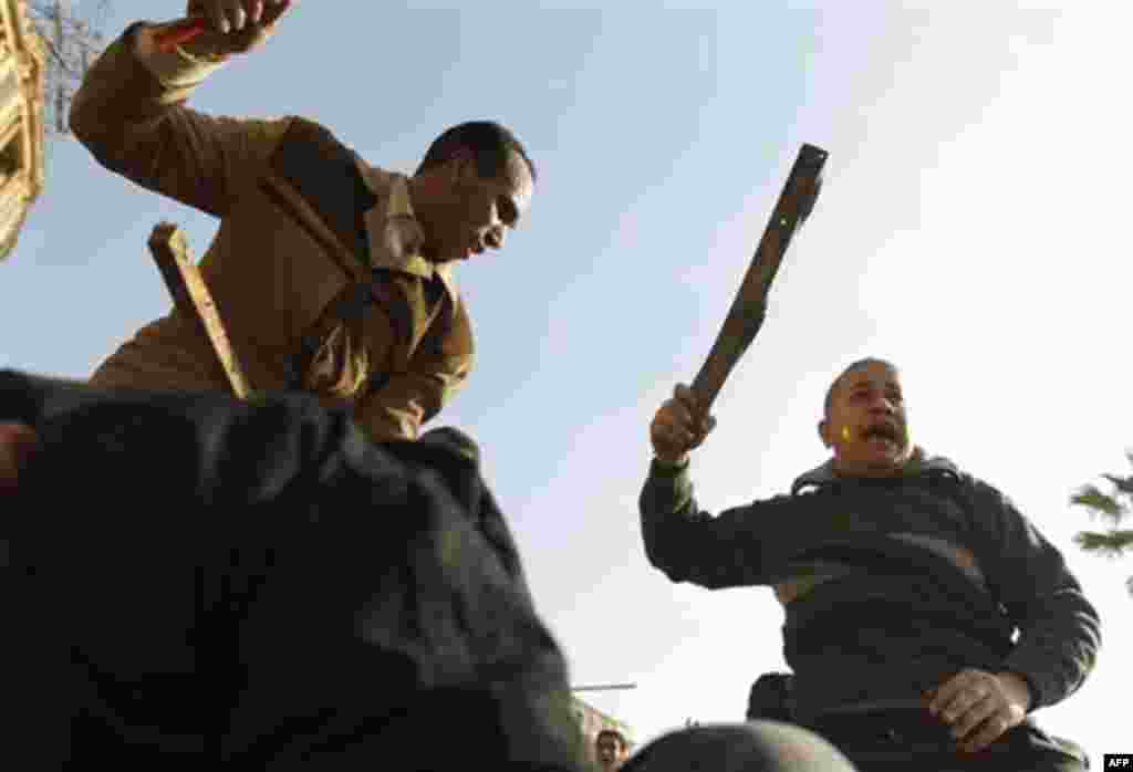 Demonstrators use sticks during clashes between pro-government supporters and anti-government protestors in Cairo, Egypt, Wednesday, Feb.2, 2011. Several thousand supporters of President Hosni Mubarak, including some riding horses and camels and wielding 