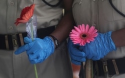 Security officers hold flowers given to them as a gesture of gratitude at the end of a free medical camp in Dharavi, one of Asia's biggest slums, in Mumbai, India, June 26, 2020.