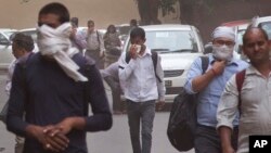 La gente se cubre la nariz en medio de una tormenta de polvo en Nueva Delhi, India, el miércoles, 2 de mayo, de 2018.