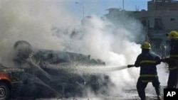 Iraqi fire fighters extinguish a fire following a car bomb explosion in Kirkuk, 180 miles (290 kilometers) north of Baghdad, Iraq, March 16, 2011