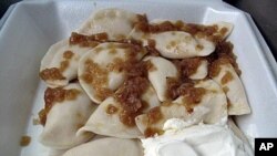 A to-go serving from St. John's Baptist Ukrainian Church includes a dozen pierogies tossed in melted butter, topped with caramelized onions and served with a generous dollop of sour cream.