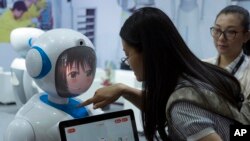 Seorang wanita berinteraksi dekat robot yang dirancang oleh perusahaan robotika China, Pangolin, dalam perhelatan Consumer Electronics Show Asia 2018 di Shanghai, China, Jumat, 15 Juni 2018 (foto: AP Photo/Sam McNeil)