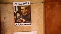 Fotografija ruskog opozicionog lidera Alekseja Navalnog stoji na zidu dok ljudi prisustvuju bdijenju nakon njegove smrti, Pariz, 19. februar 2024.
