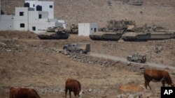 Tanques y vehículos militares israelíes maniobran durante un ejercicio en los Altos del Golán controlados por Israel cerca de la frontera con Siria, el martes 4 de agosto de 2020.