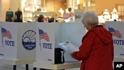 Delores Engel looks over her ballot while voting at the West Ridge Mall in Topeka, Kansas, Nov. 5, 2024.