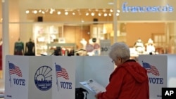 Seorang warga tampak mengamati surat suara saat menggunakan hak pilihnya dalam pemilu Amerika Serikat di sebuah TPS di West Ridge Mall di Topeka, Kansas, pada 5 November 2024. (Foto: AP/Charlie Riedel)