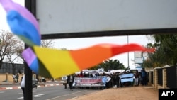 FILE - A rainbow flag is seen as demonstrators from the Coalition of Botswana Christian Churches chants slogans against homosexuality and hold placards while marching toward the Parliament of Botswana on July 22, 2023. 
