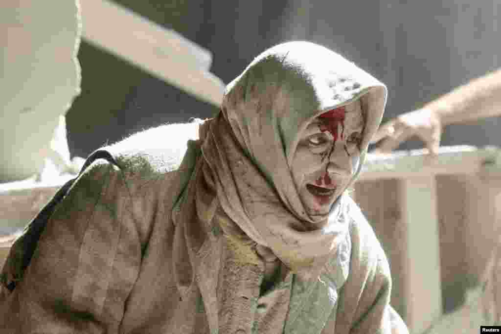 An injured woman reacts at a site hit by airstrikes in the rebel held area of Old Aleppo, Syria.