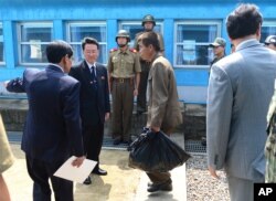 FILE - An unidentified North Korean fisherman, center, crosses the borderline at Panmunjom in Paju, South Korea, July 14, 2015. South Korea said Tuesday that it had sent back two North Korean fishermen who were rescued earlier this month from South Korean waters.