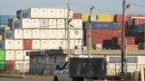 Un camion passe devant des conteneurs d'expédition à Port Newark, dans le New Jersey, le 4 octobre 2024.