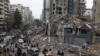 People gather as cars drive past rubble from damaged buildings in Beirut's southern suburbs, after a ceasefire between Israel and Iran-backed group Hezbollah took effect at 0200 GMT on Nov. 27, 2024.