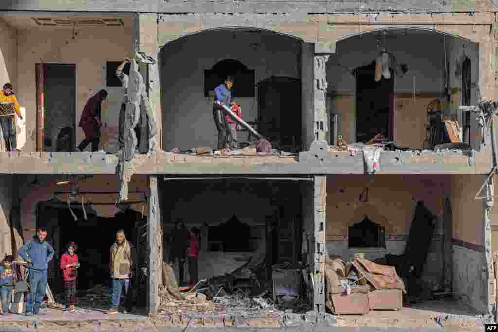 Palestinian men check the debris at a building, following overnight Israeli airstrikes in Rafah refugee camp in the southern Gaza Strip, amid continuing battles between Israel and the Palestinian militant group Hamas.&nbsp;