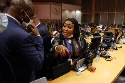 Pan African Parliament member Maria Traore speaks to another inside the house following its postponement in Midrand, Johannesburg on June 1, 2021.