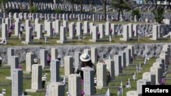 Warga Korea Selatan Jo Kyung-ho memberikan penghormatan di depan nisan saudara lelakinya Jo Chang-ho yang meninggal selama Perang Korea 1950-1953, pada malam Hari Peringatan Korea Selatan di Pemakaman Nasional di Seoul, Korea Selatan, Senin , 5 Juni 2017. (Foto: Reuters)