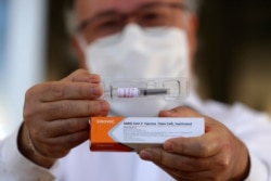 Dr. Gustavo Romero, of University Hospital of Brasilia’s Nucleus of Tropical Medicine, presents to the press China’s Sinovac Biotech experimental coronavirus vaccine before it is administered to volunteers in Brasilia, Brazil, Aug. 5, 2020.