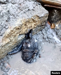 A newly discovered 2,300-year-old bronze statue lies on the ground in San Casciano dei Bagni, Italy, in this handout photo obtained by Reuters on November 8, 2022. (Ministero della Cultura/Handout via REUTERS)