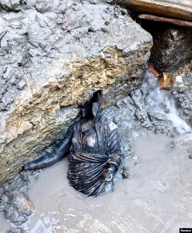 A newly discovered 2,300-year-old bronze statue lies on the ground in San Casciano dei Bagni, Italy, in this handout photo obtained by Reuters on November 8, 2022. (Ministero della Cultura/Handout via REUTERS)