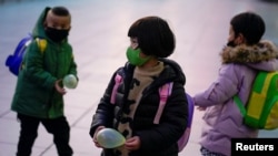 戴著口罩的兒童在上海火車站 （2020年3月5日） 