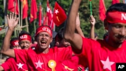 FILE - Supporters of Myanmar's opposition leader Aung San Suu Kyi's National League for Democracy party wave party flags ahead of a campaign rally in Thandwe, western Rakhine state, Myanmar.