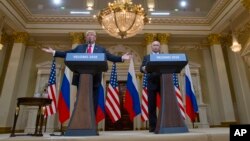 U.S. President Donald Trump, left, gestures while speaking as Russian President Vladimir Putin, right, listens during their joint news conference at the Presidential Palace in Helsinki, Finland, July 16, 2018.