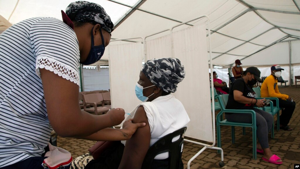 A woman receives a dose of a COVID-19 vaccine at a center, in Soweto, South Africa, Monday, Nov. 29, 2021. Scientists have warned for months that the coronavirus will thrive as long as vast parts of the world lack vaccines. (AP Photo/Denis Farrell)