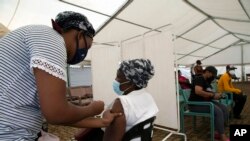 Une femme reçoit une dose d'un vaccin COVID-19 dans un centre de Soweto, en Afrique du Sud, le 29 novembre 2021.