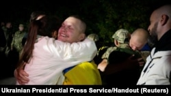 FILE - A Ukrainian prisoner of war embraces a loved one after being released as part of a prisoner swap in an undisclosed location in Ukraine, in this handout picture obtained from the Ukrainian Presidential Press Service via Reuters on Oct. 19, 2024.