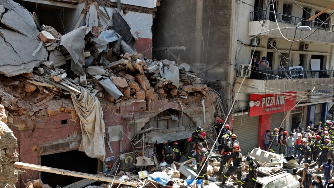 File - French and Lebanese firemen search in the rubble of a building after the explosion of Aug. 4, 2020 at the seaport of Beirut, Lebanon.