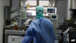 Un médecin surveille un patient atteint du coronavirus en traitement dans l'unité de soins intensifs de l'hôpital de Brescia en Italie, le 16 mars 2020. (Photo AP)