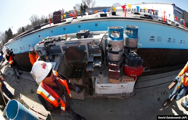 SAM, a semi-automated mason, is shown at work on a school in Englewood, Colorado.