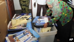 Officers from the Sudan Referendum Commission (SSRC) check voter registration kits, manuals and cards of referendum at the main distribution center in Khartoum, 08 Jan 2011