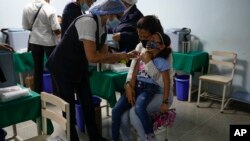 Una niña llora al ser vacunada durante una campaña de inoculación contra la polio, la rubeola y la influenza organizada por el Ministerio de Salud de Venezuela en Caracas, el 18 de junio del 2022. 