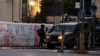 FILE - A soldier of the Israeli army stands next to a military vehicle in a street near the building where the Al Jazeera office was stormed and closed, in Ramallah, in the Israeli-occupied West Bank, Sept. 22, 2024. 