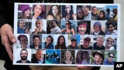FILE - A photo collage of the 34 victims of the Sept. 2, 2019 fire aboard the dive boat, Conception, at Santa Cruz Island, is held by a family member arriving at federal court in Los Angeles, Oct. 25, 2023. 