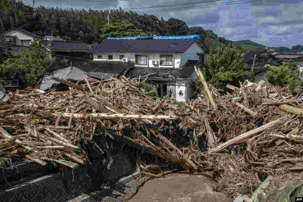 Debris washed away from flooding is seen piled by a house along the Tsukada River following heavy rain in Wajima city, Ishikawa prefecture, Japan.