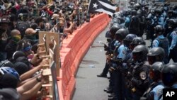 Demonstrators holding wooden shields are confronted by police during a protest against the Federal Fiscal Control Board, as part of the May Day celebration in San Juan, Puerto Rico, May 1, 2019.