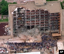 FILE - In this May 5, 1995, photo, search and rescue personnel attend a memorial service in front of the Alfred P. Murrah Federal Building in Oklahoma, destroyed by a fertilizer bomb in what is considered the first major domestic terrorist attack in the U.S.