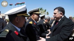 Fayez Serraj, à droite, à son arrivée à Tripoli, en Libye, le mercredi 30 mars 2016.