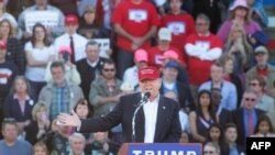 Kandida repibliken Donald Trump antoure ak patizan pandan li tap pale nan yon meeting nan stad yon lekòl nan vil Madison, Eta Alabama, yon jou anvan Sipè Madi premye mas 2016 la.