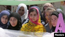 Penerima Nobel Perdamaian Malala Yousafzai (tengah) berpose dengan anak-anak perempuan di sekolah untuk anak perempuan pengungsi Suriah, yang dibangun oleh LSM Kayany Foundation, di Lembah Bekaa, Lebanon, 12 Juli 2015. 