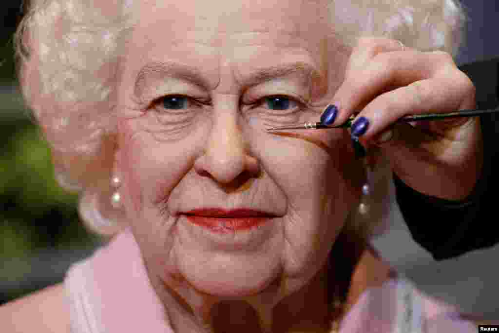 Artist Emma Meehan applies final touches on a new waxwork of the Queen, in Blackpool, Britain.