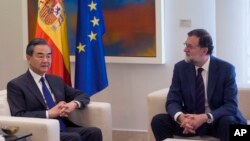 China's Foreign Minister Wang Yi, left, and Spain's Prime Minister Mariano Rajoy pose for the media during their meeting in Madrid, May 17, 2018. 