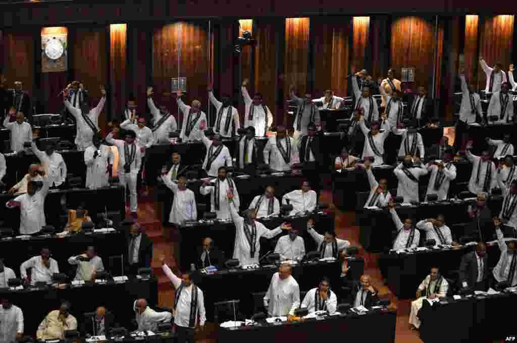 Members of the Sri Lankan parliament raise their hands at a session in Colombo. Sri Lanka&#39;s parliament passed a motion of no-confidence in the controversially appointed government of Mahinda Rajapakse a day after the Supreme Court overturned a presidential decree dissolving the legislature.