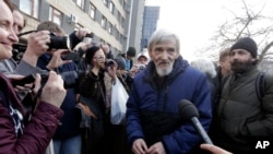FILE - Russian historian Yuri Dmitriyev, center, speaks to the media outside a court in the city of Petrozavodsk, northwestern Russia, April 5, 2018.