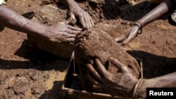 Laborers shape mud bricks as they work at a kiln in Karjat, India, March 10, 2016.