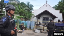 Police stand near the scene of an explosion outside a church in Samarinda, East Kalimantan, Indonesia, Nov. 13, 2016.