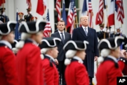 President Donald Trump and French President Emmanuel Macron stand during a State Arrival Ceremony on the South Lawn of the White House in Washington, April 24, 2018.